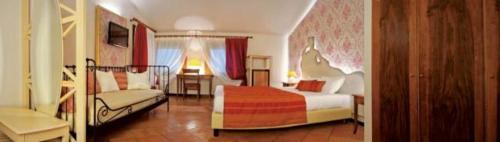 a hotel room with a bedroom with a bed and a couch at Hotel Villaguarda Prosecco Area in Follina