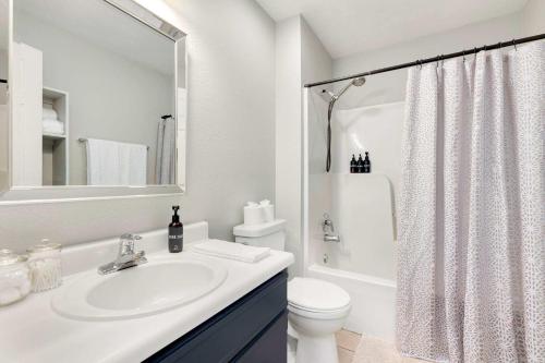 a white bathroom with a sink and a toilet at Campus Corner-1 Mi to UofA- 1 Mi to Downtown in Fayetteville