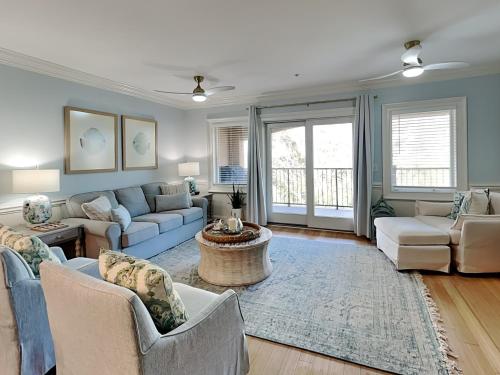 a living room with couches and a table at Brass Rail 318 in Tybee Island