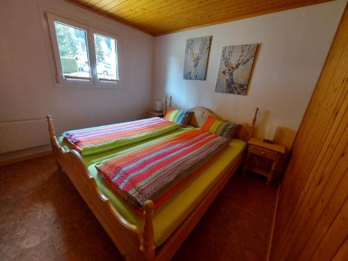 a bedroom with a bed with a colorful blanket on it at Ferienwohnung EnFiNi in Fieschertal