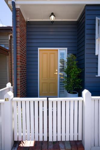 a front door of a blue house with a white fence at Cottage D'Or in Ballarat