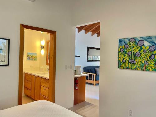 a room with a bathroom with a sink and a mirror at Weezie's Ocean Front Hotel and Garden Cottages in Caye Caulker