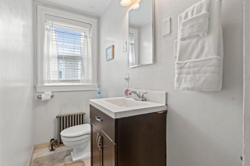 a bathroom with a sink and a toilet and a window at Bryn Mawr Gembalconydedicated Parking50tv in Bryn Mawr