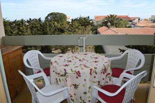 une table et des chaises assises sur un balcon avec une table dans l'établissement Résidence Le Carlton - 2 Pièces 4 couchages PORT LEUCATE. Réf: 2CAR_218C MAE-5171, à Leucate