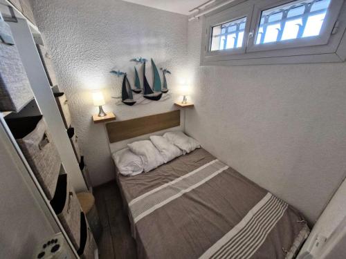 - un petit lit dans une petite maison avec deux lampes dans l'établissement Résidence Le Carlton - 2 Pièces 4 couchages PORT LEUCATE. Réf: 2CAR_218C MAE-5171, à Leucate