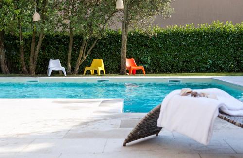 a dog laying on a lounge chair next to a swimming pool at Hotel Villaguarda Prosecco Area in Follina