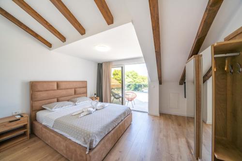 a bedroom with a large bed and a balcony at Apartment Coral in Brodarica