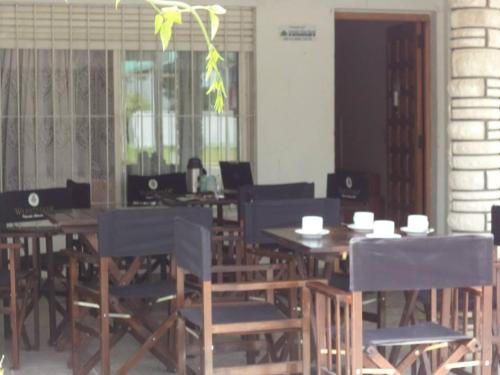 una sala da pranzo con tavoli, sedie e finestre di Mar del Faro a Mar del Plata
