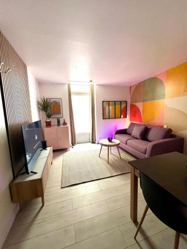 un salon avec un canapé et une table dans l'établissement Victoria, Wifi, Terrasse, Patio, TV, Centre Historique, Charme, à La Rochelle