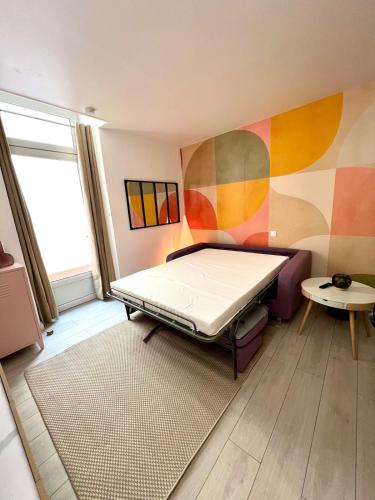 une petite pièce avec un lit et une table dans l'établissement Victoria, Wifi, Terrasse, Patio, TV, Centre Historique, Charme, à La Rochelle