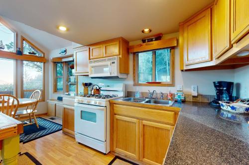 a kitchen with white appliances and wooden cabinets at Whaleshead Wonderland in Carpenterville
