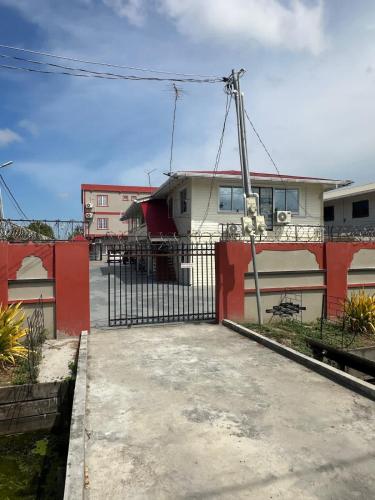 a fence in front of a building with a house at Senior Suite 3 Bedroom in Beterverwagting