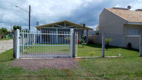 a white fence in front of a house at Casa Praia Recreio Torres RS in Torres