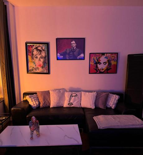 a living room with a couch and pictures on the wall at Romeo et juliette in Spa