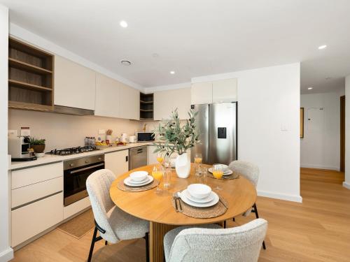 a kitchen with a wooden table and chairs at The Cinema Suite Luxury 2-Bed Near Dubai Mall in Dubai