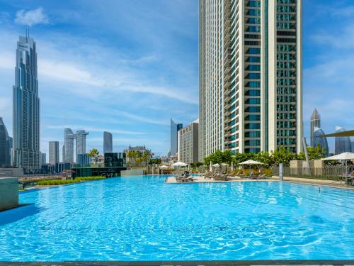 a large swimming pool in a city with tall buildings at The Cinema Suite Luxury 2-Bed Near Dubai Mall in Dubai
