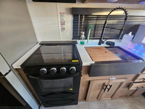 a kitchen with a stove and a sink at Sun TinyHouse E Pahrump in Pahrump