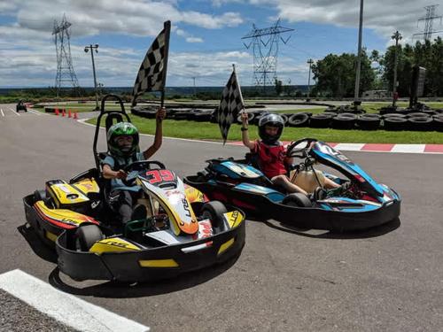 two people are riding in go karts at 1900s Historic Charm -Free P+AC in Boischâtel