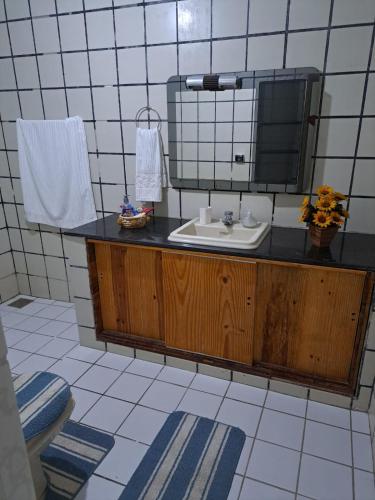 a bathroom with a sink and a mirror at Suite para casal in Natal