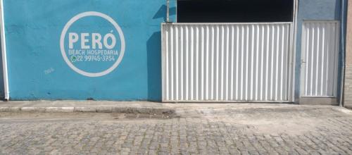 a blue wall with a pcoro sign on it at Peró Beach Hospedaria in Cabo Frio