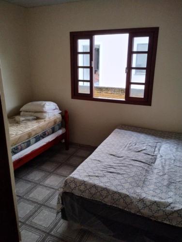 una camera da letto con due letti e una finestra di Possibilidade a Governador Celso Ramos