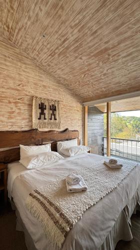 a bedroom with a large bed with a wooden ceiling at Hotel Arrebol in Castro