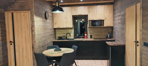 a kitchen with a small table and a microwave at Domki na Cieńkowie in Wisła