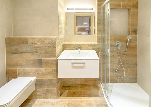 a bathroom with a sink and a toilet and a shower at Hotel Orion in Abertamy