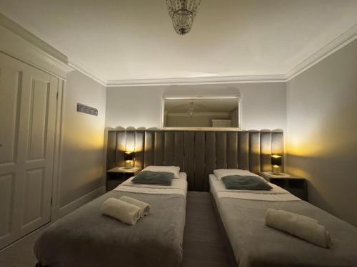 two beds in a small room with two lamps at Villa Śnieżka in Kowary