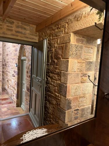 a mirror reflecting a brick wall with a door at Pietra Rossa in Chios