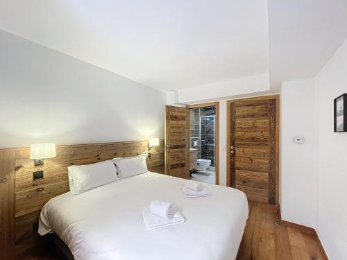 une chambre avec un lit blanc avec deux serviettes dessus dans l'établissement Tamaris - Morzine - secteur Planet, à Morzine