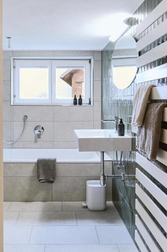 a bathroom with a sink and a bath tub at Ferienhaus Mell Aroma in Mellau