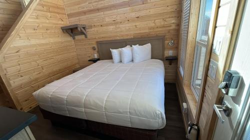a bedroom with a white bed in a wooden room at 063A Brand New Cozy Cabin with Loft & King bed near Grand Canyon South Rim in Valle