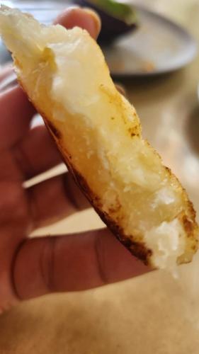 a hand holding a doughnut with icing on it at La divina trinidad - Galeria Wellness Hostal in Cali