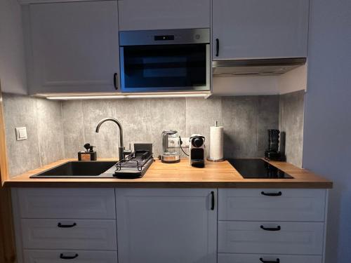 a kitchen counter with a sink and a microwave at Alpenfels Zwieselstein in Sölden