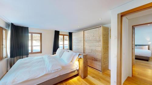 a bedroom with a bed with a wooden wall at Chalet Rominger-Surlej in Surlej