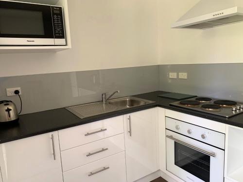 a kitchen with a sink and a microwave at Tongariro Crossing Lodge in National Park