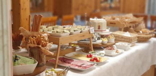 a table topped with dishes of food on plates at Alpenotel Rosenhof Ruhpolding, Wellness, Chiemgau Karte, Travelingo Bonus Programm in Ruhpolding