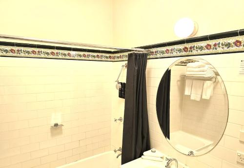 a bathroom with a mirror and a tub and a toilet at Palais Royale in Katoomba