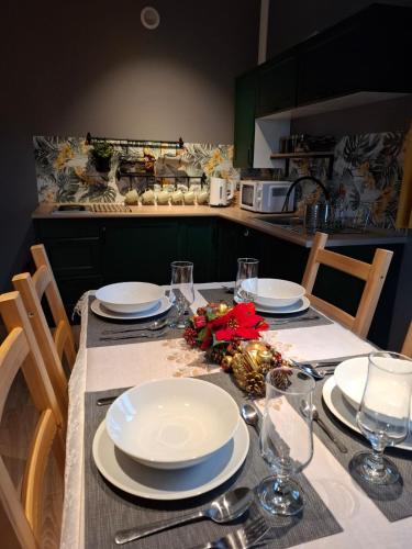 a table with plates and glasses on it in a kitchen at Domki z Widokiem in Wünschelburg