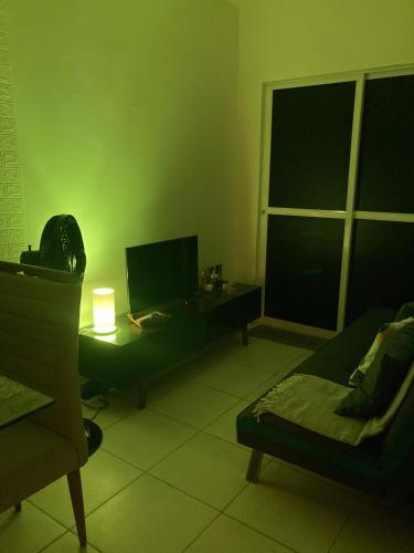 a living room with a bed and a desk with a television at Economize e aproveite a região ou descanse para o voo - 24h in Maceió