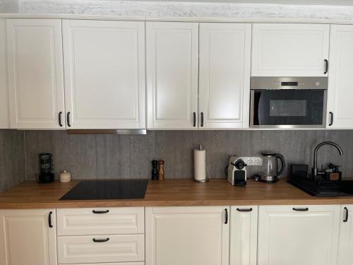 a kitchen with white cabinets and a counter top at Alpenfels Zwieselstein in Sölden
