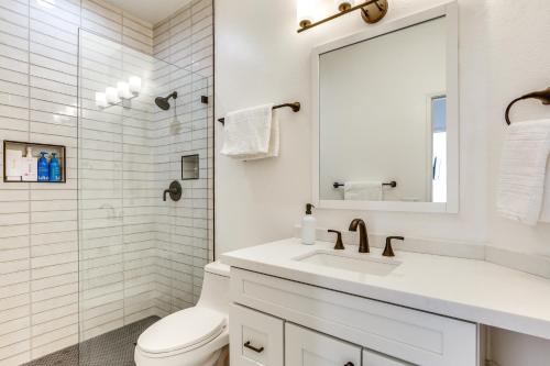a white bathroom with a sink and a mirror at 2 Mi to Coachella Indio Oasis with Heated Pool in Indio