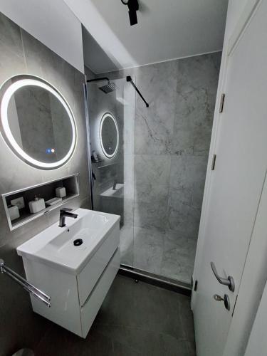 a bathroom with a white sink and a shower at RONApartament in Bacău