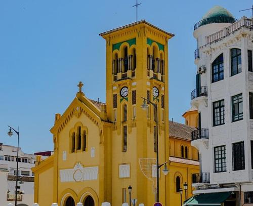 a yellow building with a clock tower in a city at central app Medina Tetouan 15 min airport in Tetouan