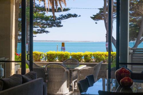 a patio with a table and chairs and a view of the ocean at C-Scape water front apartment in Cowes