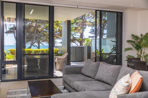 a living room with a gray couch and glass doors at C-Scape water front apartment in Cowes