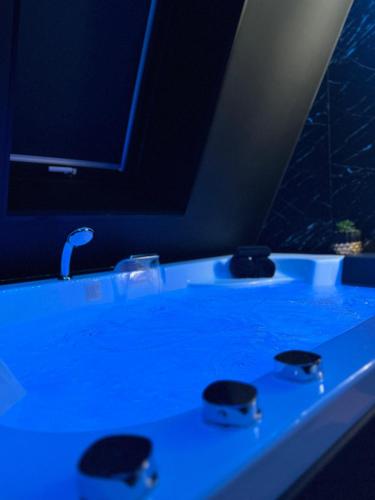 La salle de bains est pourvue d'un lavabo avec une lumière bleue. dans l'établissement DARK ROOM - Suite Luxueuse près de la mer, à Villers-sur-Mer