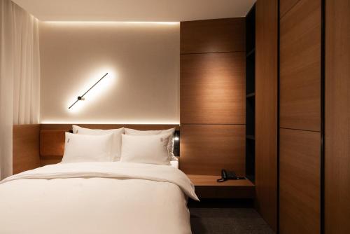 a bedroom with a bed with a clock on the wall at Garni Hotel Galeria in Banja Luka