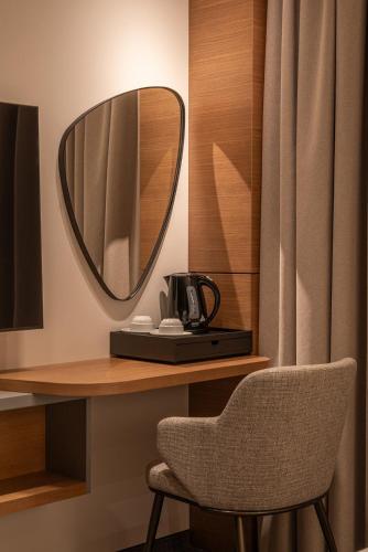a mirror sitting on a desk with a chair at Garni Hotel Galeria in Banja Luka